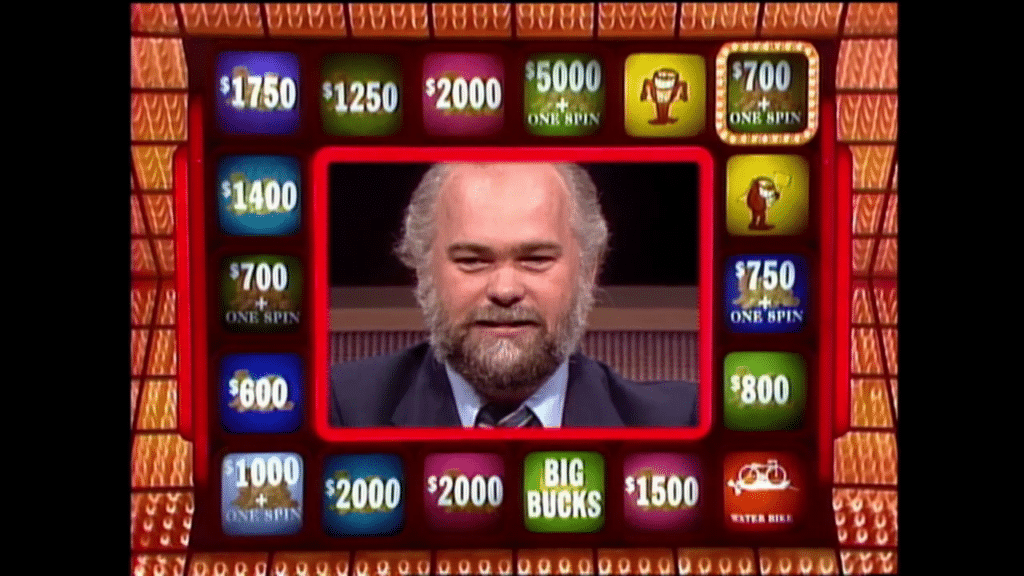 Michael Larson on screen with the money and Whammy boxes around face