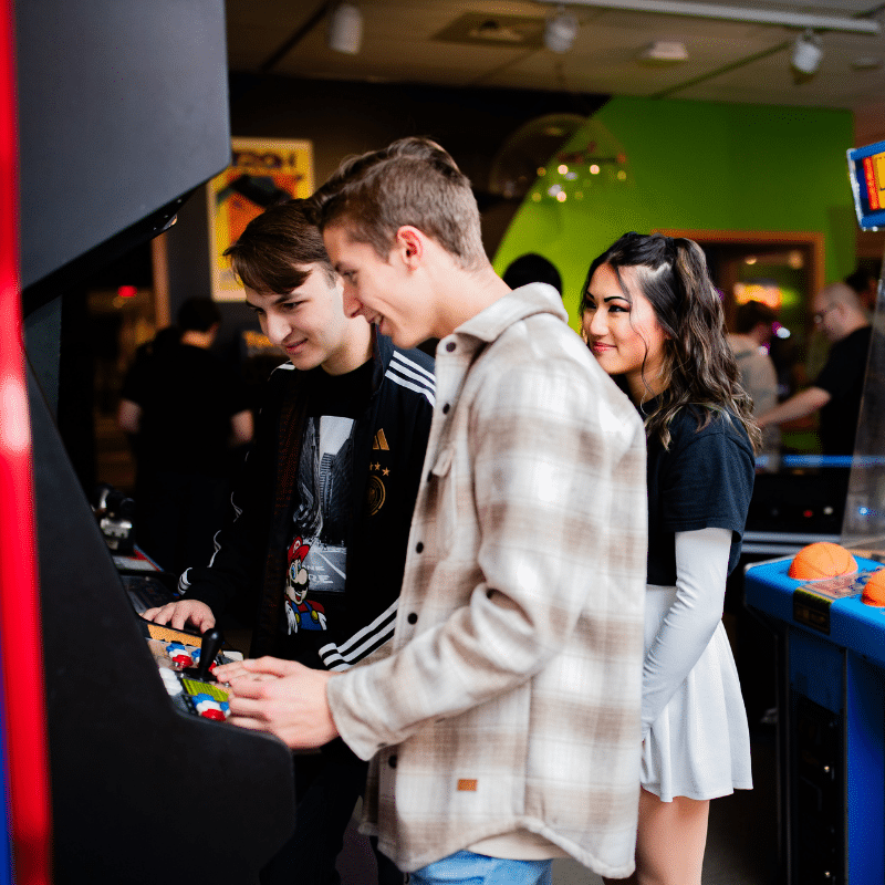 College kids playing an arcade game